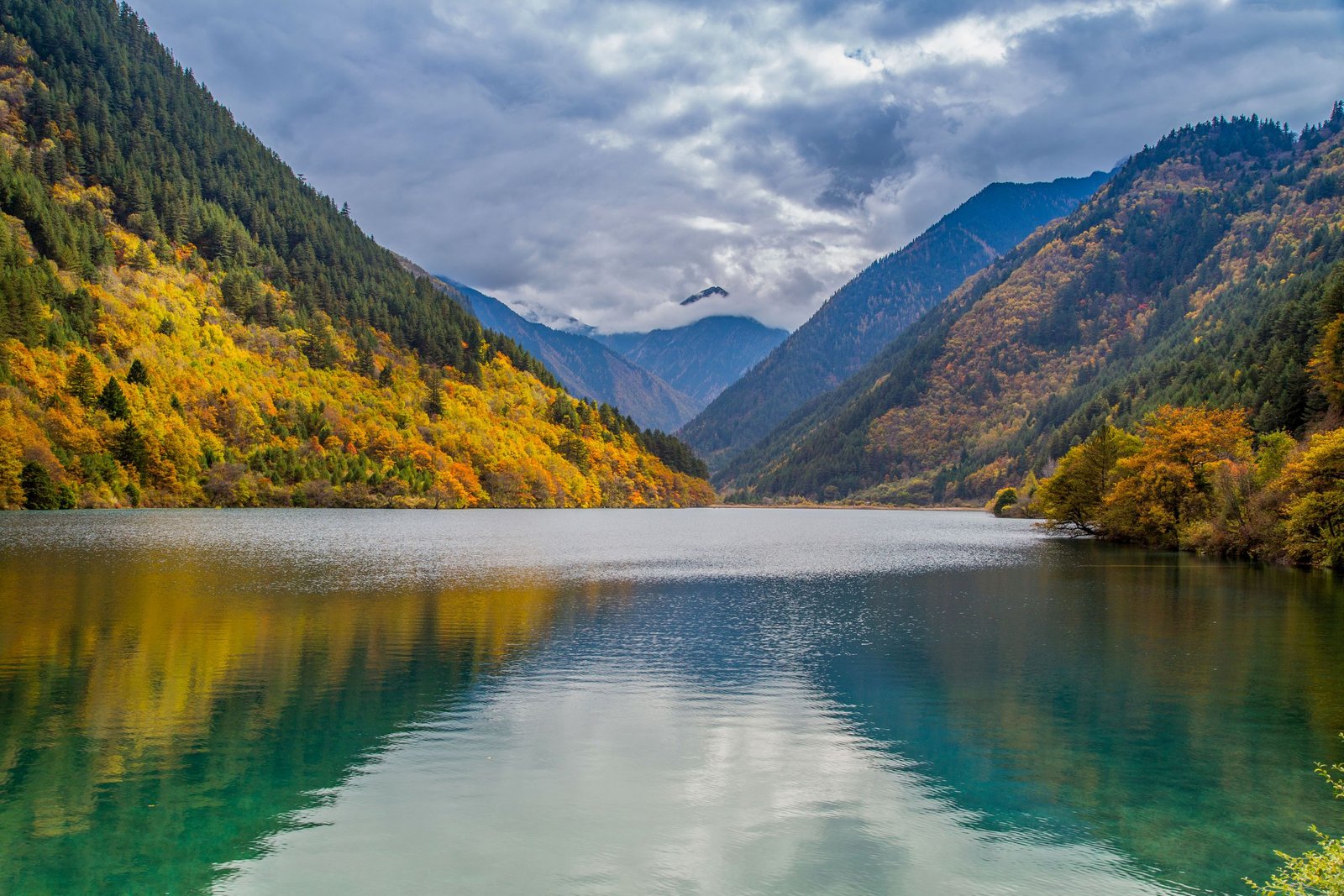 Autumn-coloured mountains surrounding a lake in Jiuzhaigou.